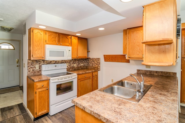 kitchen featuring dark wood-style flooring, white appliances, recessed lighting, tasteful backsplash, and a sink