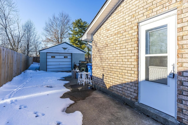 view of snow covered exterior with a garage and an outdoor structure