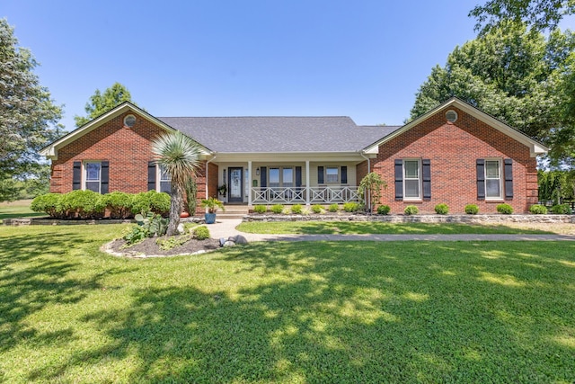 ranch-style home featuring covered porch and a front lawn