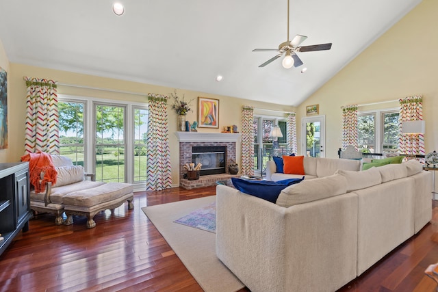 living room featuring a fireplace, plenty of natural light, dark wood-type flooring, and ceiling fan