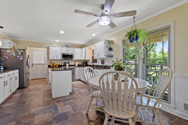 dining room with crown molding, sink, and ceiling fan