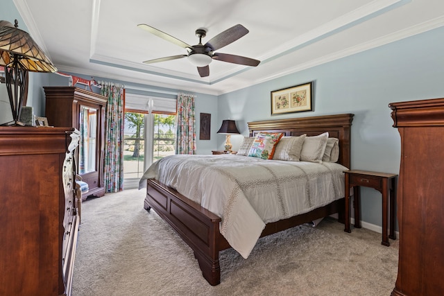 bedroom featuring ceiling fan, a raised ceiling, ornamental molding, and light carpet