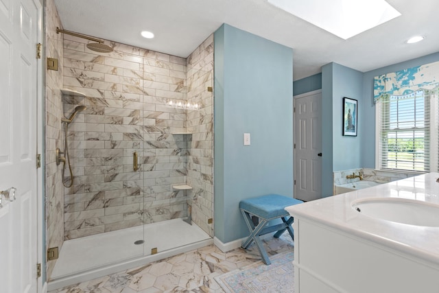 bathroom featuring vanity, a skylight, and a shower with door