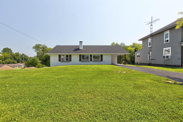 view of front of property featuring cooling unit and a front lawn