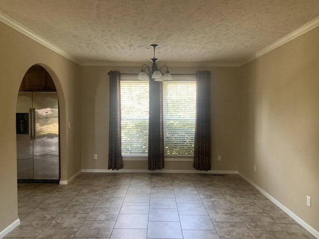 tiled spare room with a textured ceiling, an inviting chandelier, and crown molding