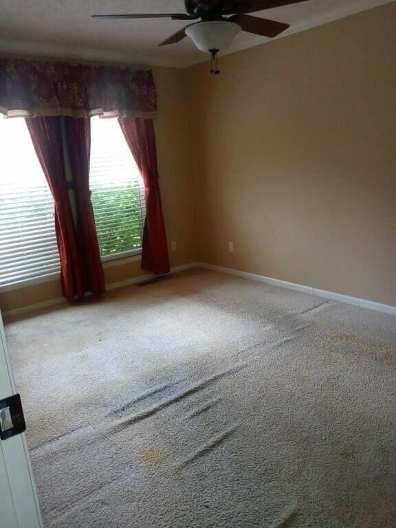 carpeted empty room featuring ceiling fan