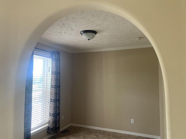 interior space featuring a healthy amount of sunlight, ornamental molding, and a textured ceiling