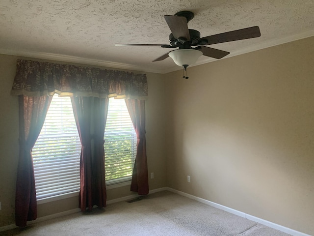 unfurnished room with ceiling fan, crown molding, carpet, and a textured ceiling