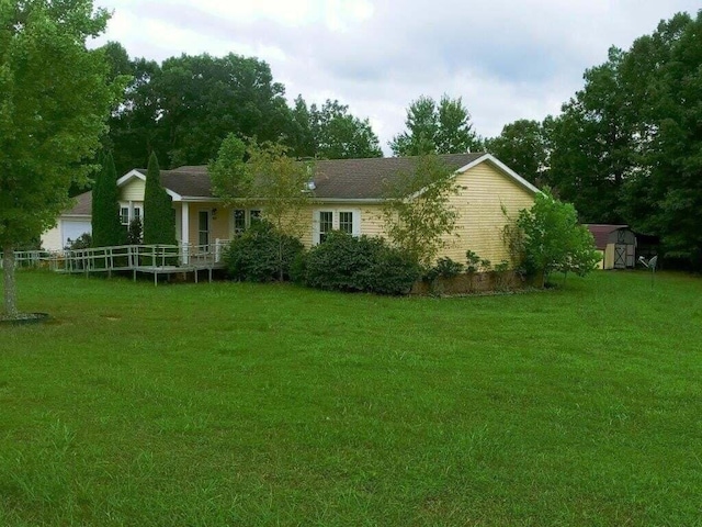 back of house with a lawn and a shed