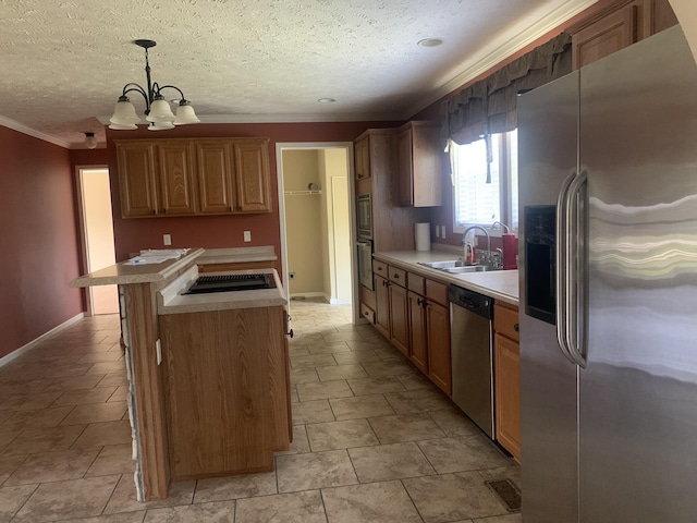 kitchen featuring an inviting chandelier, sink, a textured ceiling, appliances with stainless steel finishes, and decorative light fixtures