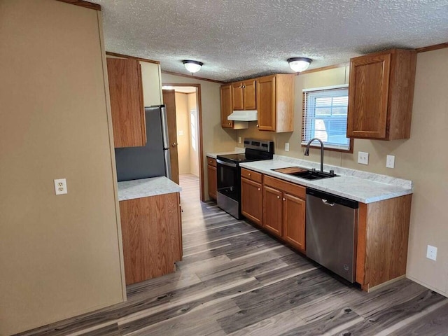 kitchen featuring a textured ceiling, stainless steel appliances, dark wood-type flooring, and sink