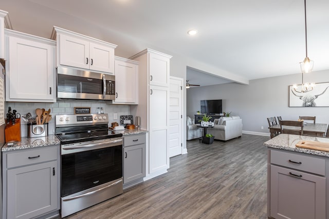 kitchen with white cabinets, gray cabinets, appliances with stainless steel finishes, and tasteful backsplash