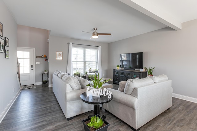 living room with beamed ceiling, ceiling fan, and dark wood-type flooring