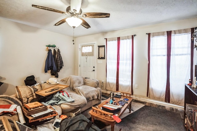 living room featuring a textured ceiling and ceiling fan