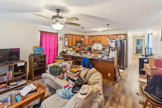 living room featuring a textured ceiling, dark hardwood / wood-style flooring, sink, and ceiling fan