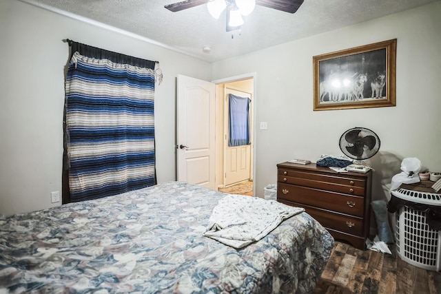 bedroom featuring ceiling fan, hardwood / wood-style floors, and a textured ceiling