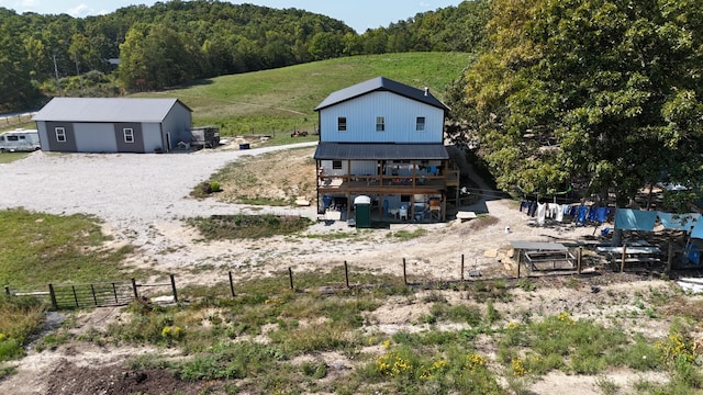 back of property with a rural view and an outdoor structure