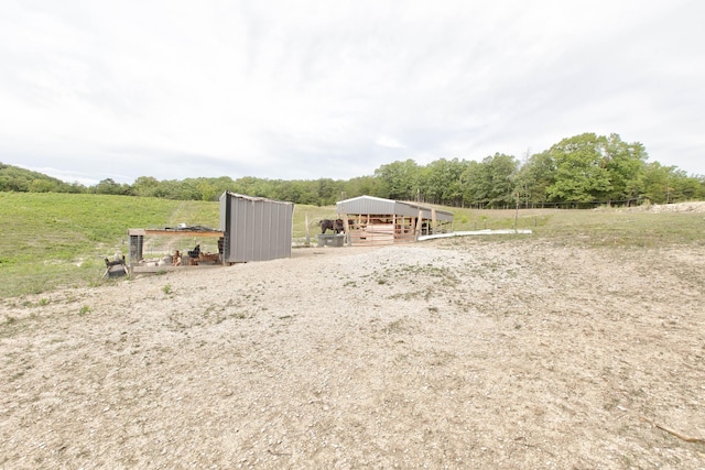 view of yard with an outbuilding and a rural view