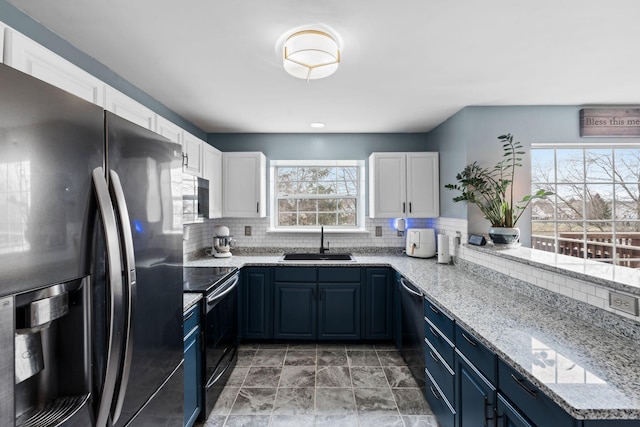 kitchen featuring white cabinetry, sink, black appliances, light stone countertops, and blue cabinetry