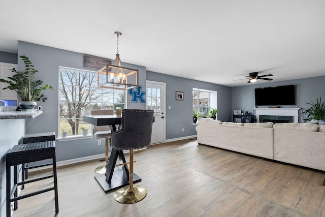 living room featuring ceiling fan with notable chandelier, hardwood / wood-style floors, and a wealth of natural light