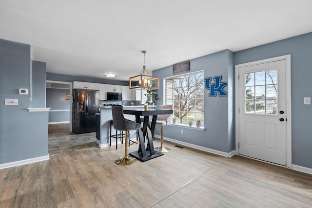 dining room featuring plenty of natural light, a notable chandelier, and light hardwood / wood-style floors