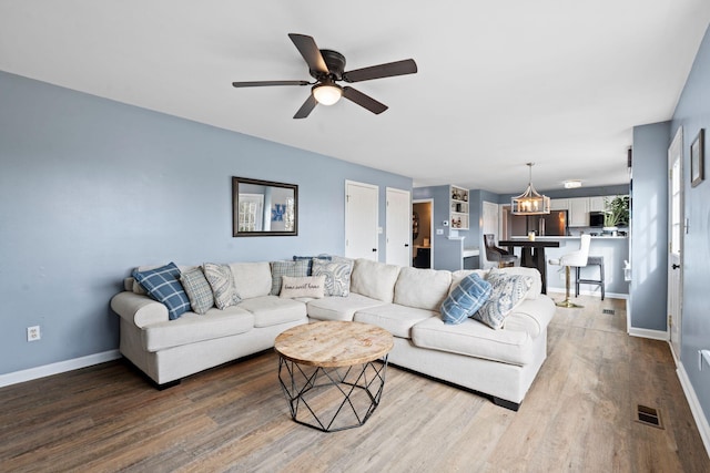 living room featuring wood-type flooring and ceiling fan