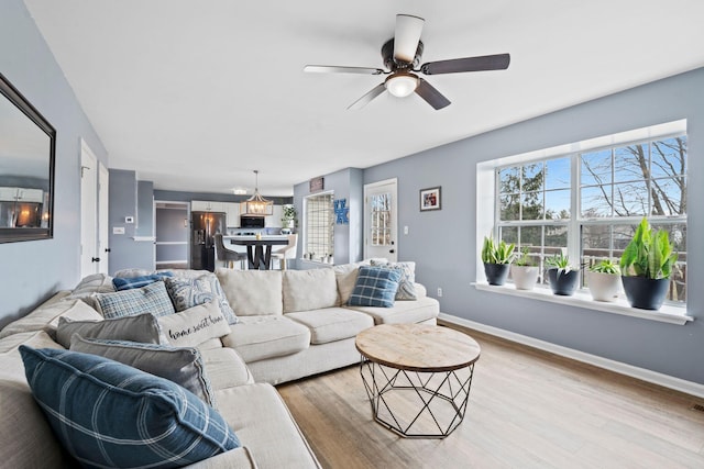 living room with ceiling fan and light hardwood / wood-style flooring