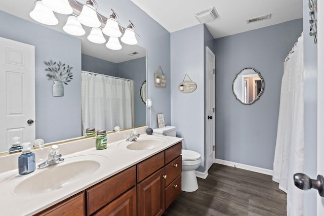 bathroom featuring wood-type flooring, toilet, and vanity