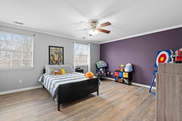 bedroom featuring wood-type flooring, ornamental molding, and ceiling fan