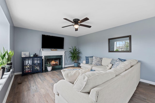 living room with ceiling fan, wood-type flooring, and a fireplace