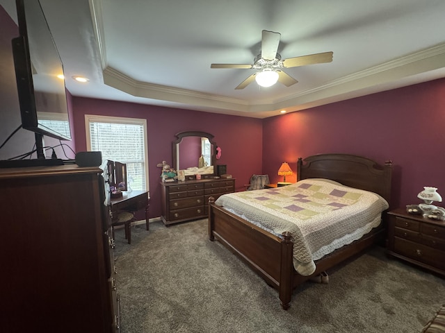 carpeted bedroom featuring ornamental molding, a tray ceiling, and a ceiling fan