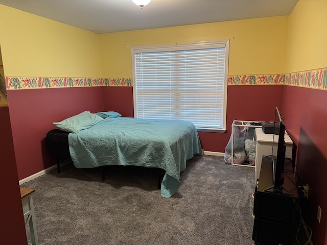 bedroom featuring dark colored carpet and baseboards