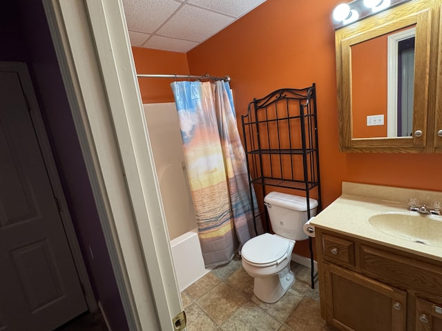 full bath with shower / bath combination with curtain, a drop ceiling, vanity, and toilet