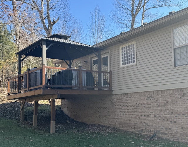 rear view of property featuring brick siding and a deck