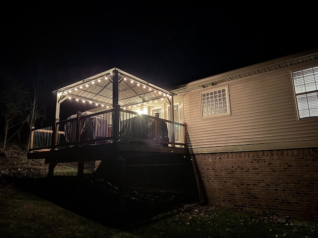 back of house at night featuring brick siding