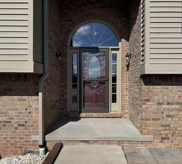 doorway to property featuring brick siding