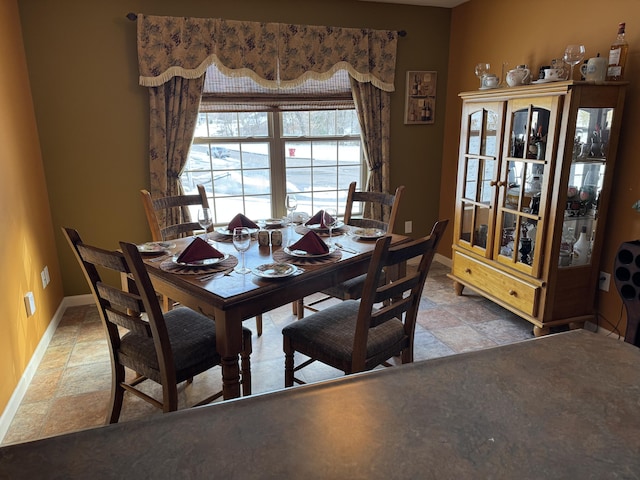 dining area with stone finish flooring and baseboards