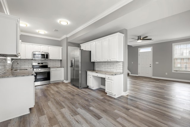 kitchen with appliances with stainless steel finishes, backsplash, ceiling fan, sink, and white cabinetry