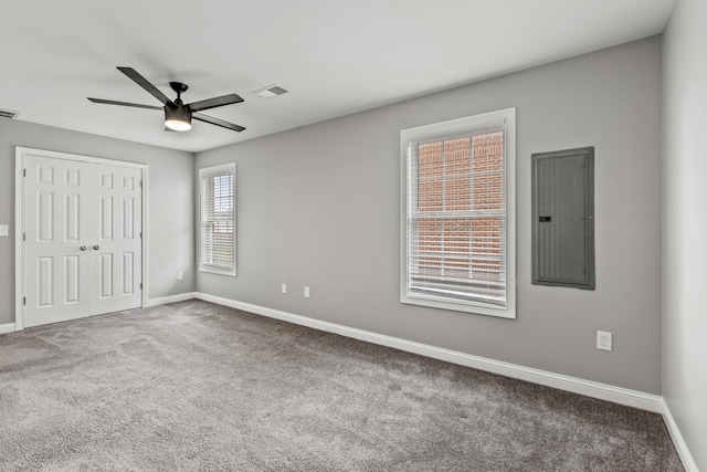 unfurnished bedroom with a closet, carpet floors, electric panel, and ceiling fan