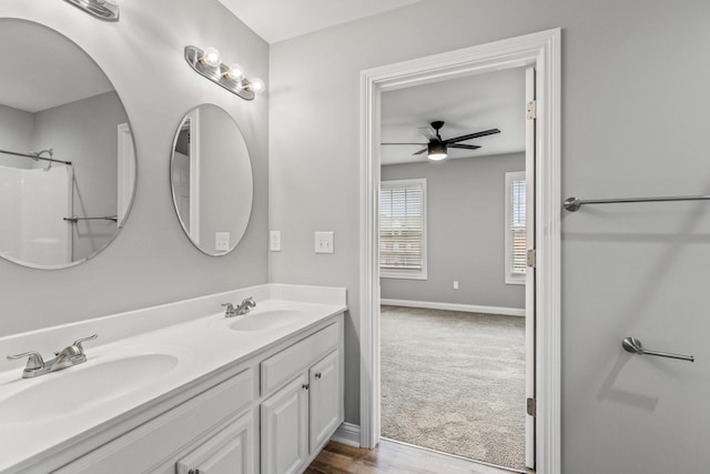 bathroom featuring ceiling fan, vanity, and walk in shower