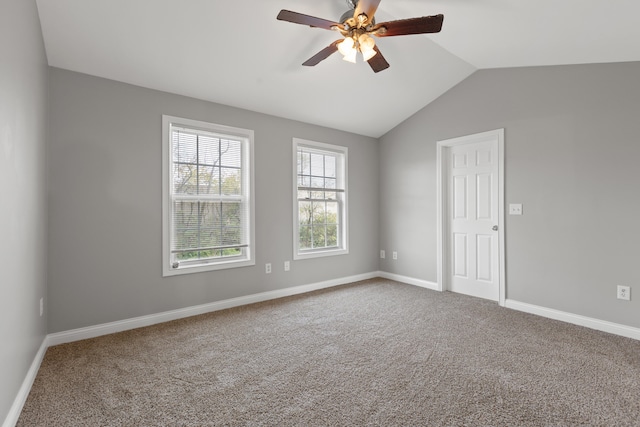 carpeted empty room featuring ceiling fan and vaulted ceiling