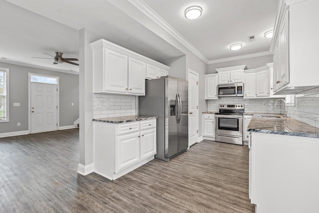 kitchen with white cabinets, sink, decorative backsplash, ceiling fan, and appliances with stainless steel finishes