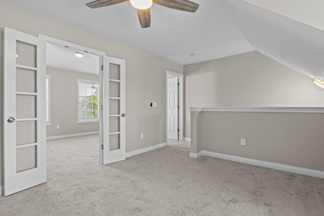 additional living space featuring french doors, light colored carpet, vaulted ceiling, and ceiling fan