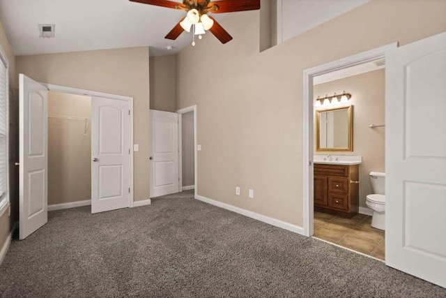 unfurnished bedroom featuring carpet, vaulted ceiling, and ensuite bath