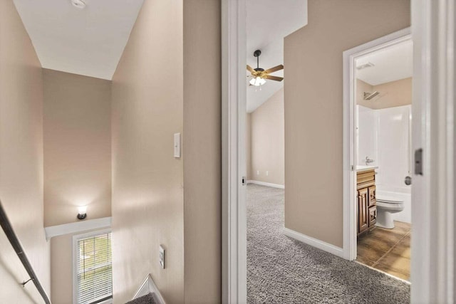 corridor with carpet flooring and vaulted ceiling