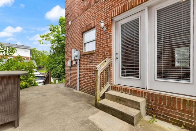 view of exterior entry with a patio