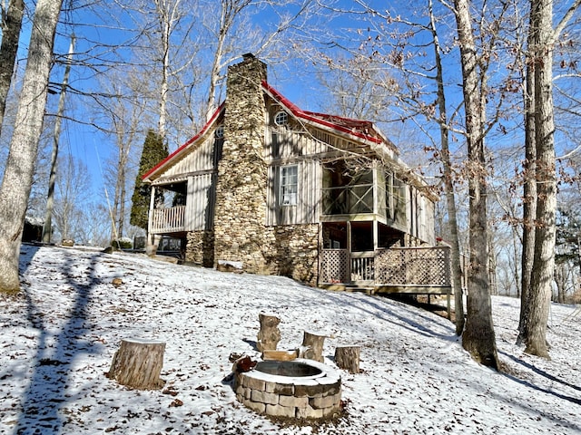 snow covered property with an outdoor fire pit