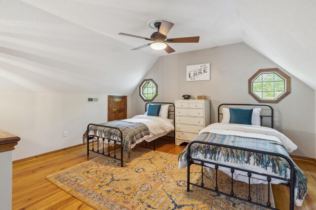 bedroom featuring ceiling fan, hardwood / wood-style flooring, and lofted ceiling