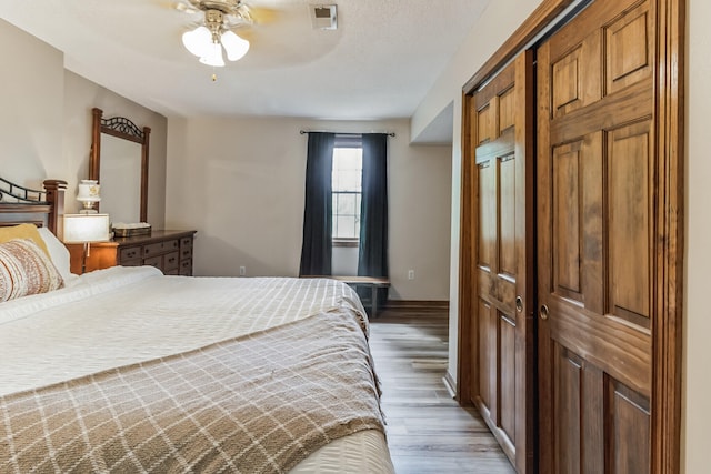 bedroom featuring ceiling fan, a closet, and light hardwood / wood-style floors