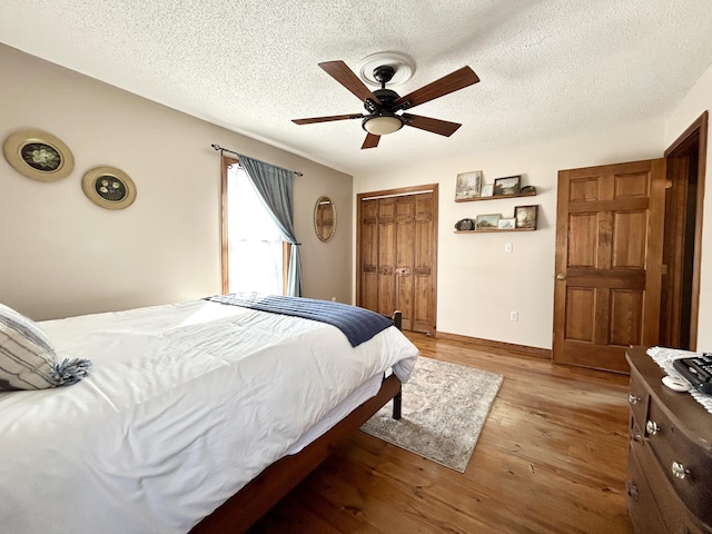 bedroom featuring a textured ceiling, ceiling fan, a closet, and hardwood / wood-style floors